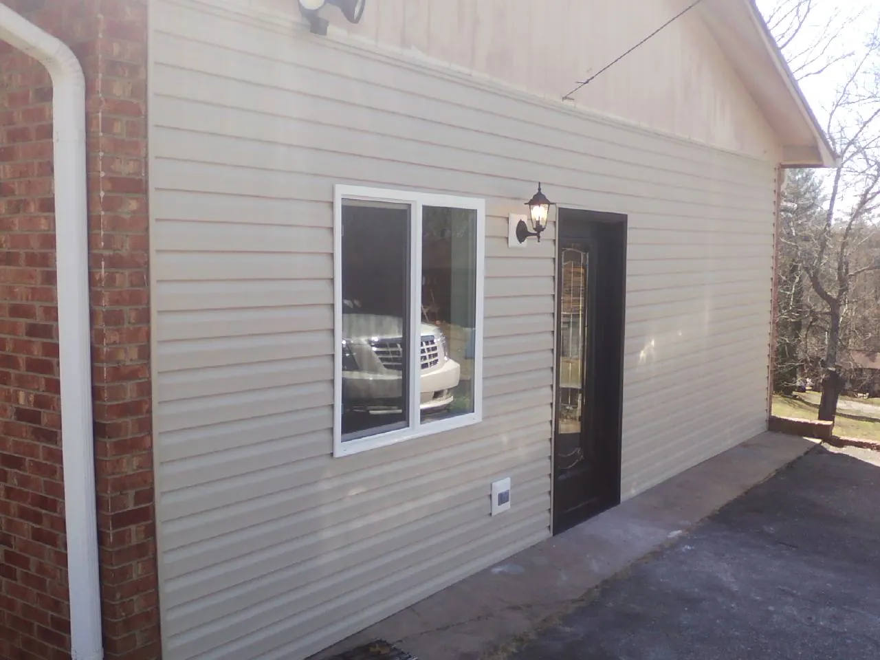 New vinyl siding and entry door on a room addition in Norris